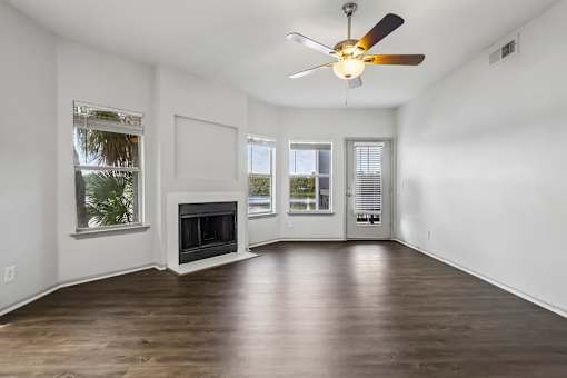 A room with a fireplace and a ceiling fan.