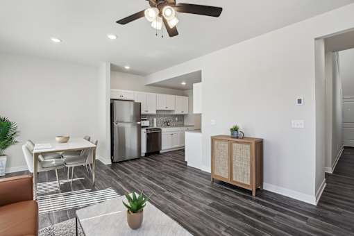 A modern kitchen with a dining table and a ceiling fan.