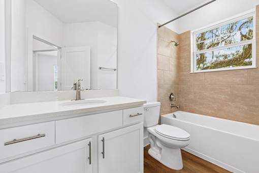 A white bathroom with a toilet, sink, and bathtub.