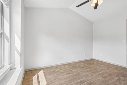 A room with wooden flooring and white walls.