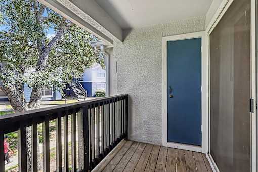 A blue door is on the right side of a white wall.
