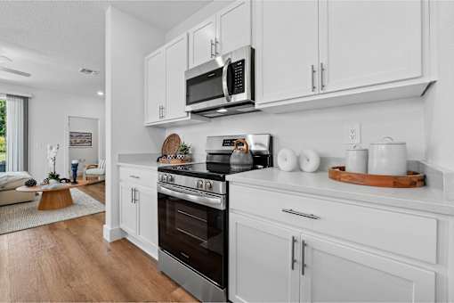 A modern kitchen with white cabinets and a stainless steel oven.