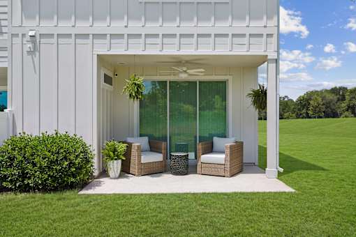 A white house with a patio and outdoor furniture.