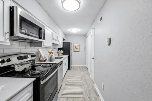 A kitchen with white appliances and a black stove top.