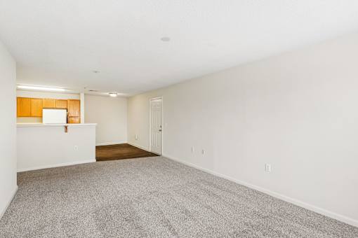 A large empty room with a carpeted floor and white walls.