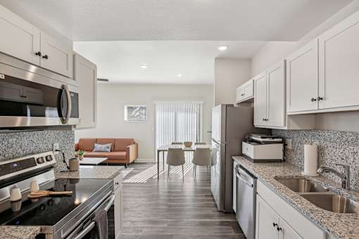 A modern kitchen with a black stove top oven and a marble counter top.