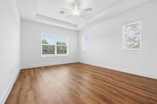A room with wooden flooring and a ceiling fan.
