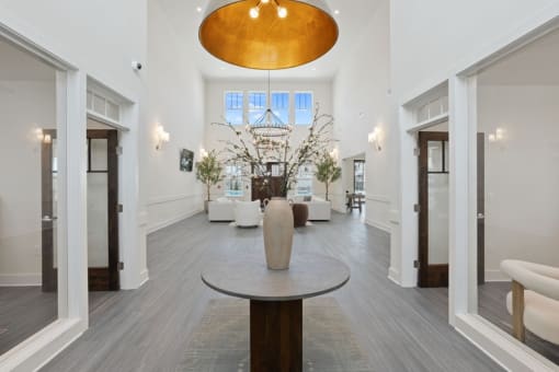 a living room with white walls and white furniture and a large pendant light