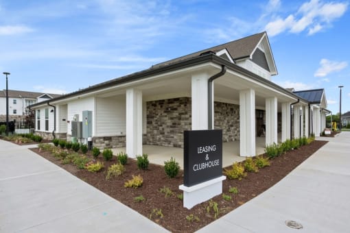 Dog-Friendly Apartments in Gallatin, TN - Banner at Westfield - Exterior View of Leasing Office and Clubhouse with Concrete Pathway and Maintained Landscaping.