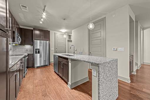 A modern kitchen with a central island and stainless steel appliances.