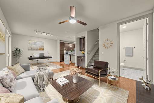 A living room with a couch, a coffee table, and a ceiling fan.