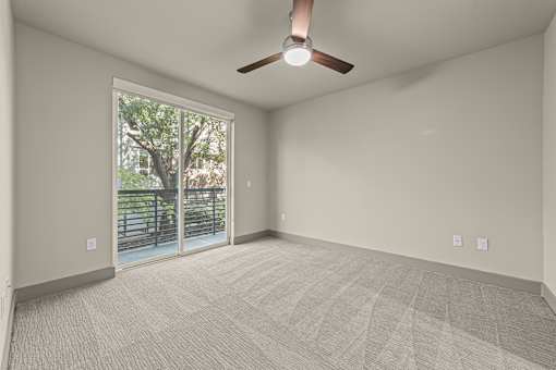 A room with a ceiling fan and carpeted floor.