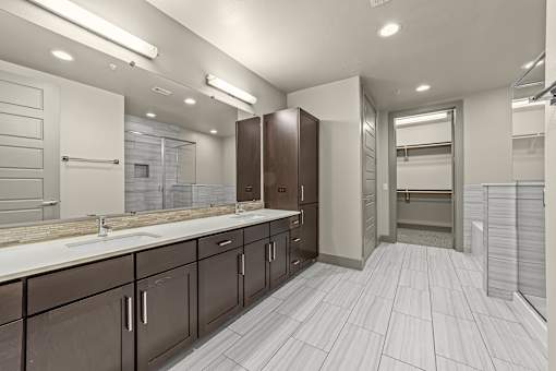 A bathroom with brown cabinets and white countertops.