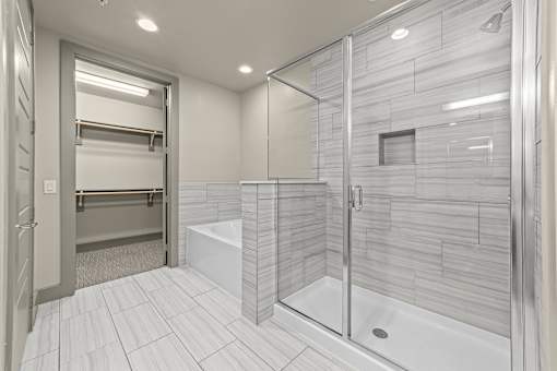 A modern bathroom with a walk-in shower and a towel bar.