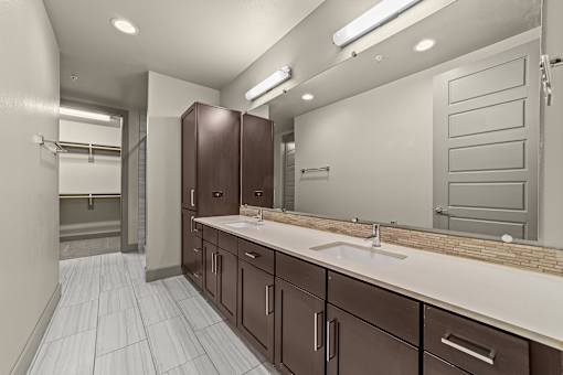 A bathroom with brown cabinets and a white sink.