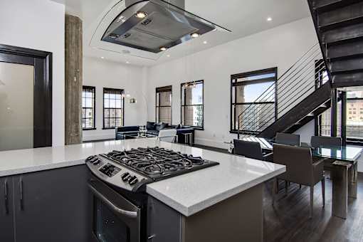 A modern kitchen with a stove top oven and a black and white color scheme.