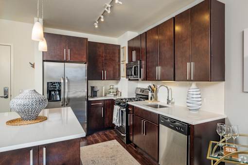 A kitchen with brown cabinets and a white counter top.