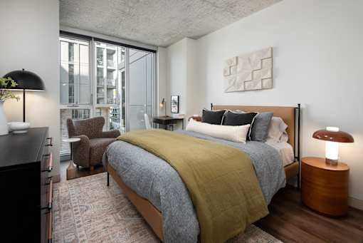 A bedroom with a large bed and a chair.