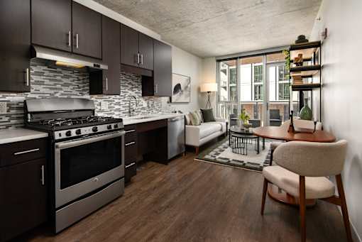 A modern kitchen with dark wood cabinets and a stainless steel stove.