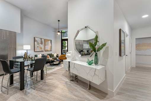 A modern dining room with a marble bench and a large mirror.