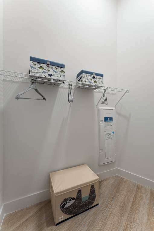 A white wall with a shelf and a box with a black and white design on it.