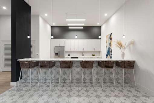 A modern kitchen with a bar area and chairs.