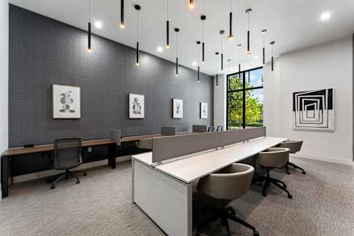 A modern office space with a long white desk and chairs.