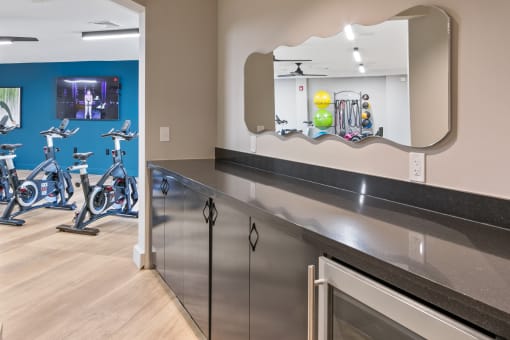 a fitness center with exercise bikes and a mirror on the wall