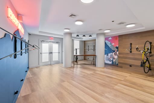 a workout room with a bike rack and a wall with a mural