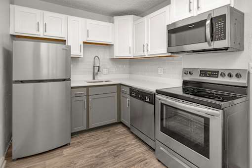 A modern kitchen with stainless steel appliances and white cabinets.