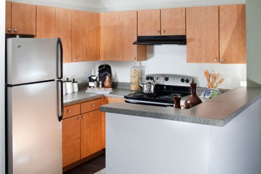 Ardenne Apartments kitchen with stainless appliances and light brown cabinets