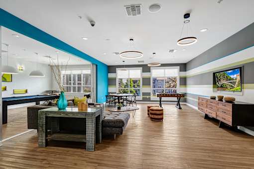 A modern living room with a dark wood floor and a blue accent wall.