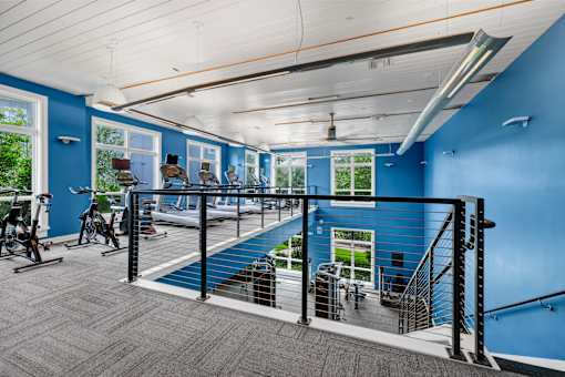 A room with blue walls and a staircase leading to a balcony.