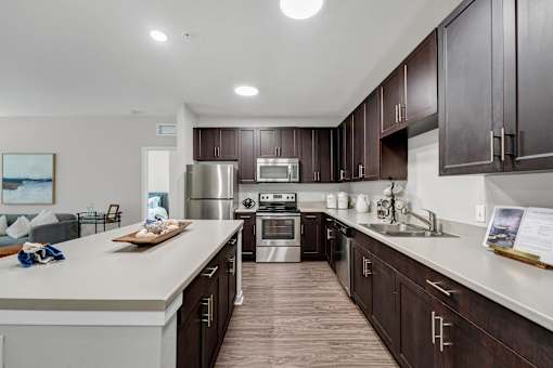 A modern kitchen with dark wood cabinets and stainless steel appliances.