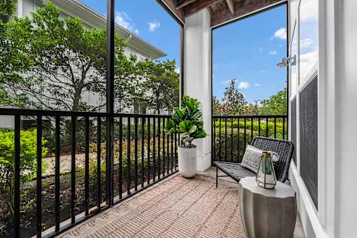 A balcony with a black railing and a bench.
