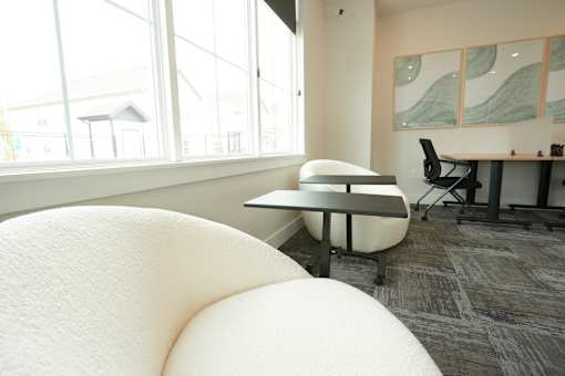 A white bean bag chair sits in a room with a desk and a chair.