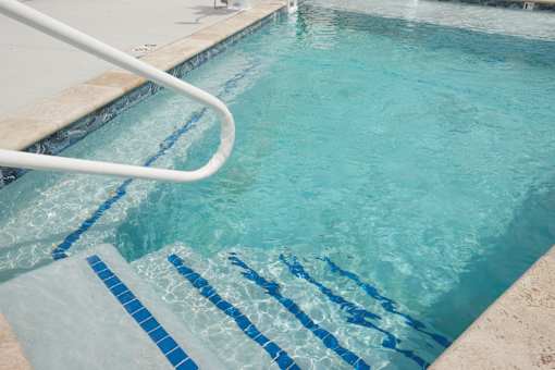 Two-Bedroom Townhomes in Raymore, MO - Ascend - Fenced Outdoor Swimming Pool With Wide Entry Steps And Poolside Handrail On Concrete Sundeck.