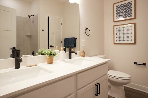A bathroom with a white counter top and a white toilet.