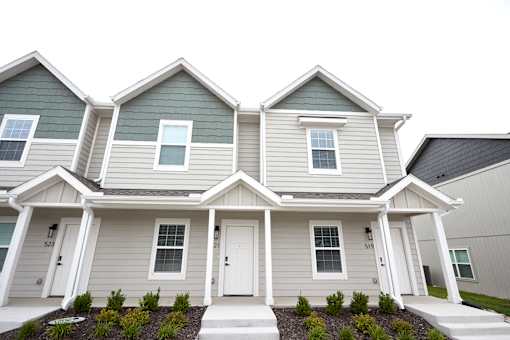 A two-story house with a grey and green exterior.