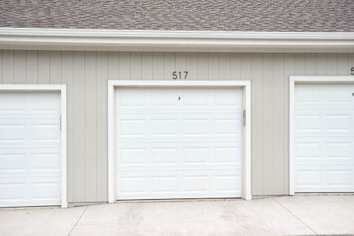 Three white garage doors are closed and numbered 517.