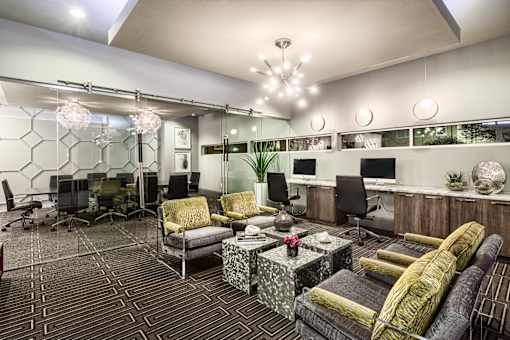 A modern living room with a patterned carpet and a variety of seating options.
