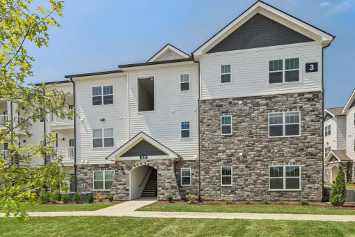 an apartment building with a stone and white facade
