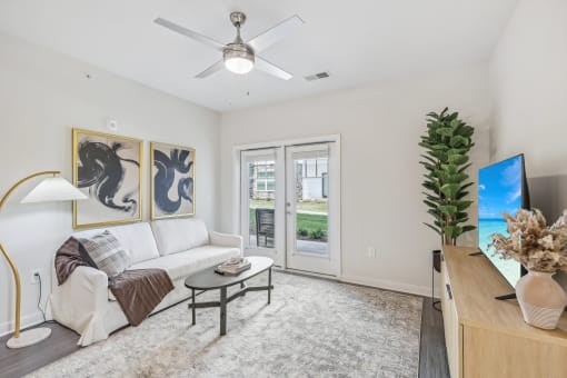 a living room with a white couch and a ceiling fan