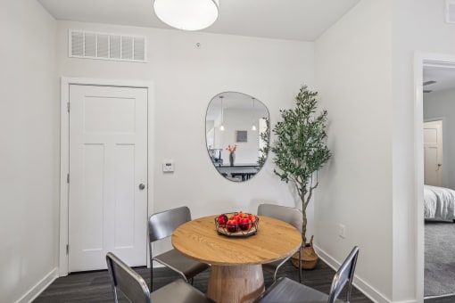 a dining room with a table and chairs and a mirror