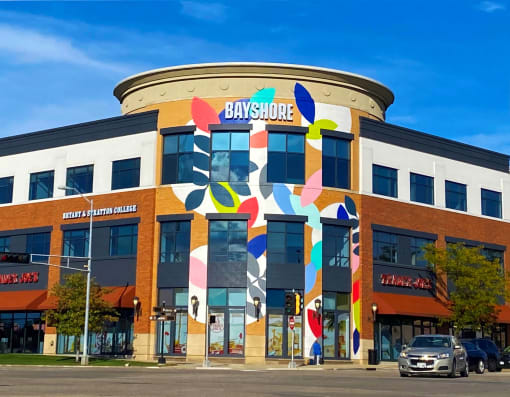 a building with a colorful mural on the side of it at The Bayshore Place Apartments in Glendale, WI