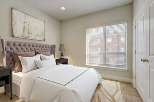 A bedroom with a large bed and a painting on the wall.