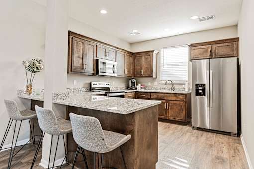 A kitchen with a granite countertop and a refrigerator.
