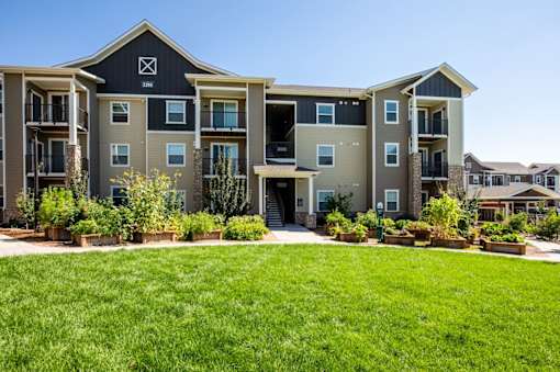 A large apartment complex with a green lawn in front.
