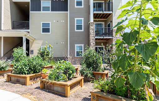 Apartment complex with a garden in front.