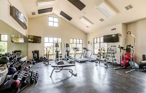 A spacious gym with a variety of equipment including treadmills, weights, and exercise machines.
